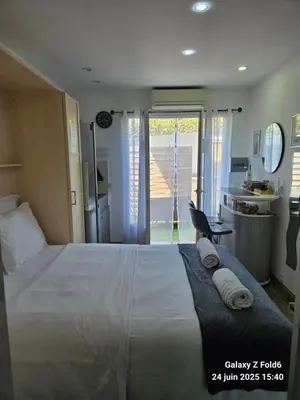 a bedroom with a large white bed with towels on it at 4 logements à La Trinité proche de Nice 15 mn, Monaco 20 mn et l'Italie 30 mn 2 Chambres et 2 Studios privés et indépendants in La Trinité