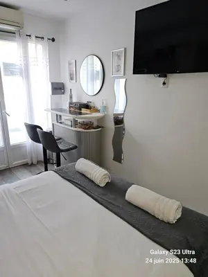 a bedroom with a bed with a flat screen tv on the wall at 4 logements à La Trinité proche de Nice 15 mn, Monaco 20 mn et l'Italie 30 mn 2 Chambres et 2 Studios privés et indépendants in La Trinité