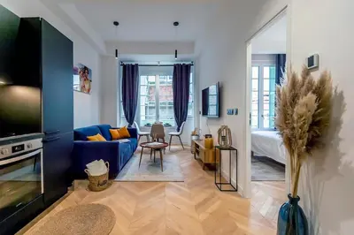 a living room with a blue couch and a bed at Superbe 2P Plage/ Promenade des Anglais 201 in Nice