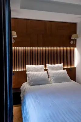 a bedroom with a large bed with a wooden headboard at Superbe 2P Plage/ Promenade des Anglais 201 in Nice