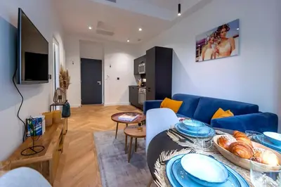 a living room with a blue couch and a table at Superbe 2P Plage/ Promenade des Anglais 201 in Nice