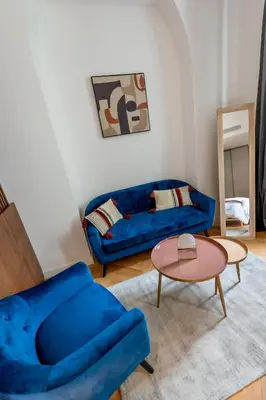 a living room with a blue couch and a table at Superbe 2P Plage/ Promenade des Anglais 203 in Nice