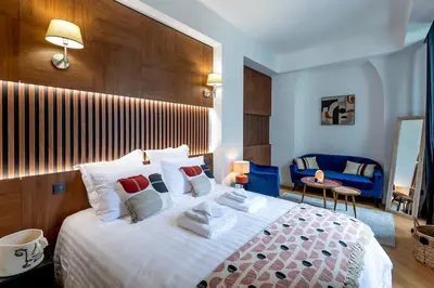 a bedroom with a large bed and a blue couch at Superbe 2P Plage/ Promenade des Anglais 203 in Nice