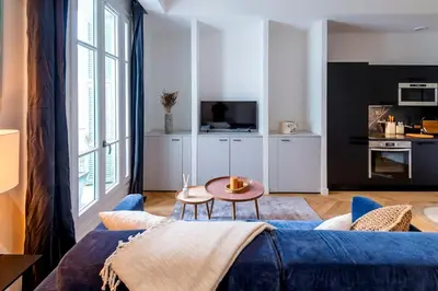 a living room with a blue couch and a table at Superbe 2P Plage/ Promenade des Anglais 203 in Nice