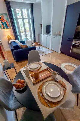a living room with a table with plates on it at Superbe 2P Plage/ Promenade des Anglais 203 in Nice