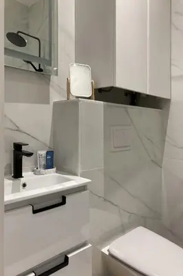 a white bathroom with a sink and a toilet at Superbe studio Plage/ Promenade des Anglais 102 in Nice