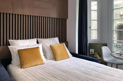 a bedroom with a large bed with two yellow pillows at Superbe studio Plage/ Promenade des Anglais 102 in Nice