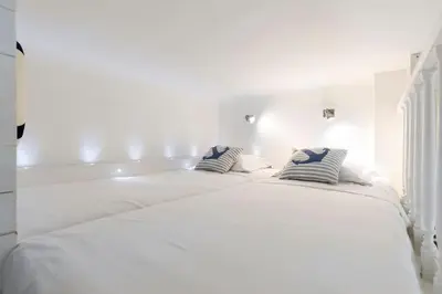 a white bed with two pillows on top of it at On Board Captain in Nice