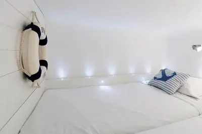 a cat sitting on a bed in a room at On Board Captain in Nice