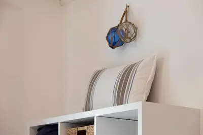 a white shelf with a pillow and a helmet on a wall at On Board Captain in Nice