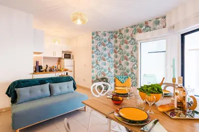 a living room with a table and a blue couch at PALAIS LIBERTE 4 AP4253 By Riviera Holiday Homes in Nice