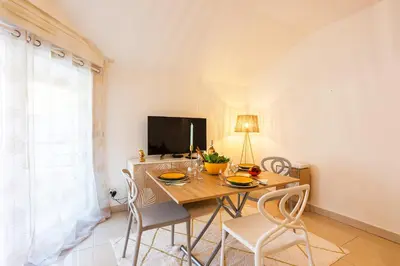 a dining room with a table and chairs and a television at PALAIS LIBERTE 4 AP4253 By Riviera Holiday Homes in Nice