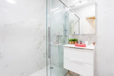 a white bathroom with a shower and a sink at PALAIS LIBERTE 4 AP4253 By Riviera Holiday Homes in Nice