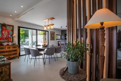 a dining room and living room with a table and a lamp at Villa Les Sources VI4245 By Riviera Holiday Homes in Nice