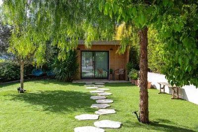 a garden with a tree and a stone path at Villa Les Sources VI4245 By Riviera Holiday Homes in Nice