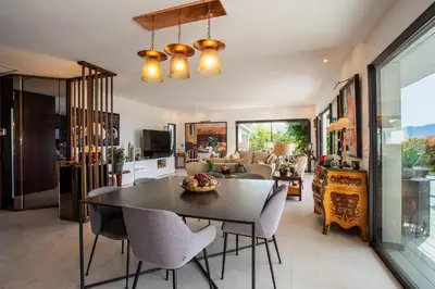 a dining room and living room with a table and chairs at Villa Les Sources VI4245 By Riviera Holiday Homes in Nice