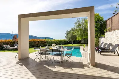 a patio with a table and chairs and a pool at Villa Les Sources VI4245 By Riviera Holiday Homes in Nice