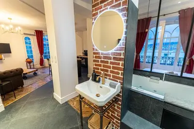 a bathroom with a sink and a brick wall at Jacuzzi-Nice quartier des musiciens-Loft in Nice
