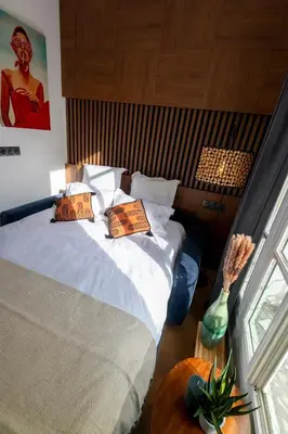 a bedroom with a bed and a table and a window at Superbe studio Plage/Promenade des Anglais 105 in Nice