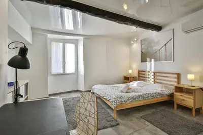 a white bedroom with a bed and a window at Jolie 2 pièces quartier Bonaparte/ Clim in Nice