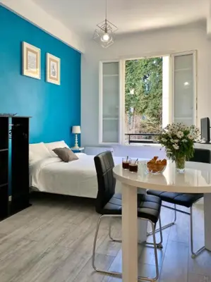 a bedroom with a bed and a table with chairs at Budget studio Berlioz in Nice