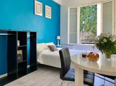 a blue bedroom with a table and a bed at Budget studio Berlioz in Nice