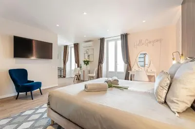 a bedroom with a large bed and a blue chair at Elegant Jacuzzi Loft in Central Massena in Nice