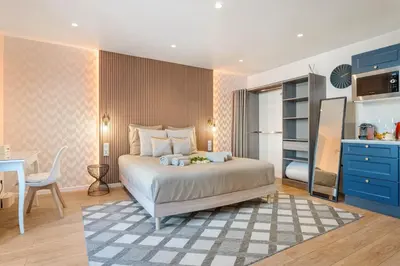 a bedroom with a bed and a table and a kitchen at Elegant Jacuzzi Loft in Central Massena in Nice