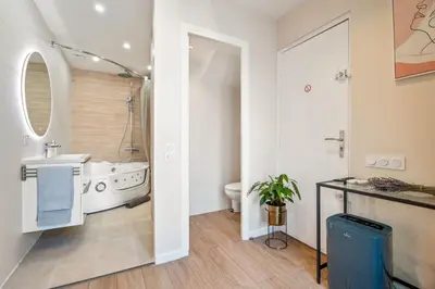 a bathroom with a tub and a sink and a toilet at Elegant Jacuzzi Loft in Central Massena in Nice