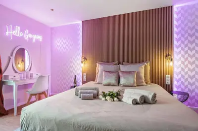 a bedroom with a large bed with purple walls at Elegant Jacuzzi Loft in Central Massena in Nice