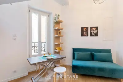 a living room with a blue couch and a table at Studio Fleur FSHH in Nice