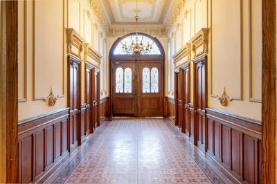 an empty hallway with a wooden door and a chandelier at Studio Fleur FSHH in Nice