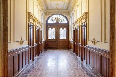 an empty hallway with a wooden door and a chandelier at Studio Fleur FSHH in Nice