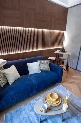 a living room with a blue couch and a table at Superbe studio Plage/ Promenade des Anglais 104 in Nice