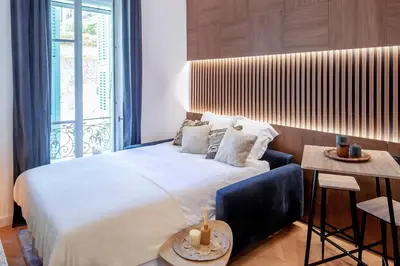 a living room with a table with plates on it at Superbe studio Plage/ Promenade des Anglais 104 in Nice