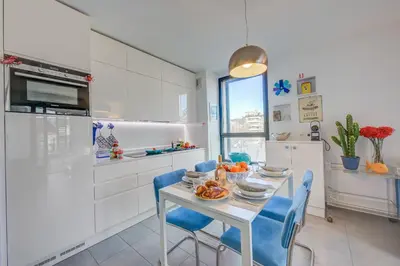 a kitchen with a white table and blue chairs at Appartement Liberation in Nice