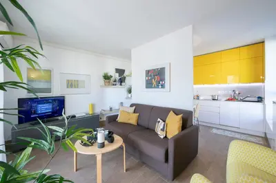 a living room with a couch and a kitchen at Appartement Liberation in Nice