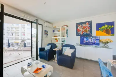 a living room with blue chairs and a tv at Appartement Liberation in Nice