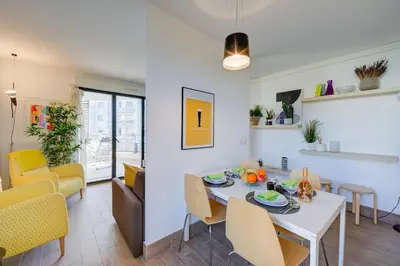 a dining room and living room with a white table and chairs at Appartement Liberation in Nice