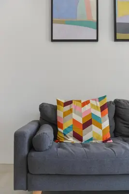a gray couch with a colorful pillow on it at Mer et Soleil - Carré d'or - 4 piéces - Centre ville - Plages à 300 m in Nice