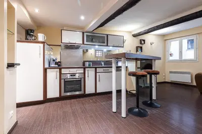 a kitchen with white cabinets and a counter top at Atypical Cozy 1 Bdr Old Town in Nice