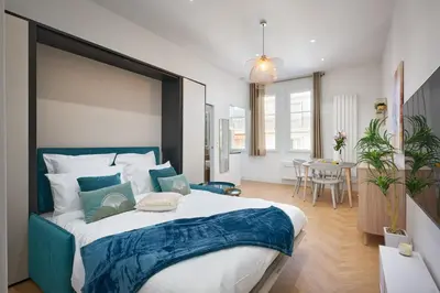 a bedroom with a large bed and a dining room at Sunlight Properties - Daffia - Beautifully renovated studio, city pad in Central Nice in Nice