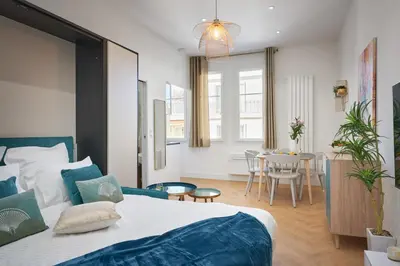 a bedroom with a large bed and a dining room at Sunlight Properties - Daffia - Beautifully renovated studio, city pad in Central Nice in Nice