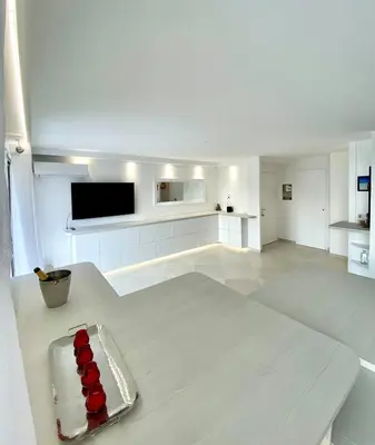 a white living room with a silver tray on the floor at Appartement Luxe - 3 pièces avec vue mer, piscine et tennis in Nice