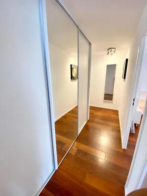 a hallway with a sliding glass door and a staircase at Appartement Luxe - 3 pièces avec vue mer, piscine et tennis in Nice