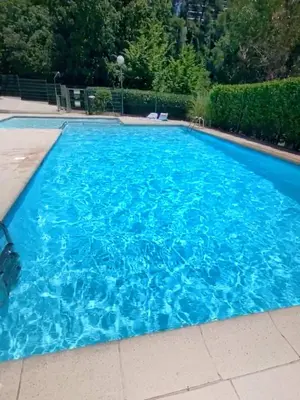 a large blue swimming pool with blue water at Appartement Luxe - 3 pièces avec vue mer, piscine et tennis in Nice