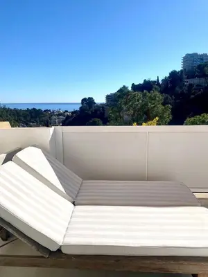a bed on the roof of a building at Appartement Luxe - 3 pièces avec vue mer, piscine et tennis in Nice