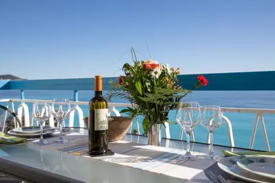 a table with a bottle of wine and wine glasses at Horizon Blue Lux Apartment in Nice