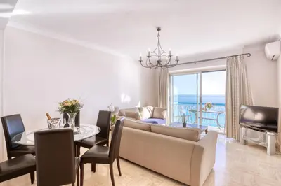 a living room with a couch and a table and a dining room at Horizon Blue Lux Apartment in Nice
