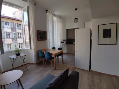 a living room with a table and a refrigerator at 2 à 6 personnes - WELCOME TO NICE ! LOGEMENT PORT in Nice
